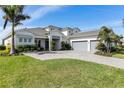 Beautiful home exterior featuring a well-maintained lawn, lush landscaping and a three car garage at 7928 Redonda Loop, Bradenton, FL 34202