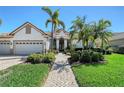 Welcoming home featuring lush landscaping, a brick walkway, and a stately entrance at 8215 Waterview Blvd, Lakewood Ranch, FL 34202