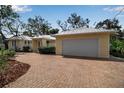 Beautiful yellow house with a brick driveway and an attached garage at 980 S Orange Ave, Sarasota, FL 34236