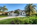 Stunning front exterior featuring a circular driveway and lush tropical landscaping at 9818 Old Hyde Park Pl, Bradenton, FL 34202