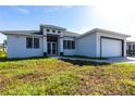 Modern home featuring a clean white exterior, dark trim, double door entry and an attached two-car garage at 10 Mast Dr # 1, Placida, FL 33946
