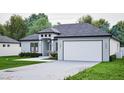 Single-story home with a two-car garage, modern architectural details, and landscaped front yard at 10 Mast Dr # 1, Placida, FL 33946