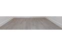 Close-up of gray wood-look vinyl plank flooring and white baseboards at 10 Mast Dr # 1, Placida, FL 33946