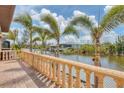 A backyard patio overlooking a canal with palm trees, lush greenery, and a boat dock at 10494 Atenia St, Port Charlotte, FL 33981