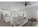 Living room featuring a neutral color palette, ceiling fan, and kitchen with stainless steel refrigerator at 10803 High Noon Trl, Parrish, FL 34219