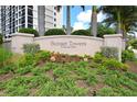 Close-up of the 'Sunset Towers' sign with manicured landscaping at 11 Sunset Dr # 303, Sarasota, FL 34236