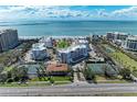 Stunning aerial view of beachfront condos, tennis courts, and lush landscaping at 1465 Gulf Of Mexico Dr # 104, Longboat Key, FL 34228
