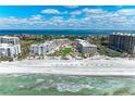 Stunning aerial view of beachfront property with pristine sands, turquoise waters, and luxury condos at 1465 Gulf Of Mexico Dr # 104, Longboat Key, FL 34228