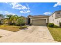Charming single-story home with a two car garage, a well maintained lawn, and beautiful Florida landscaping at 16612 Myrtle Sand Dr, Wimauma, FL 33598