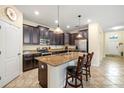 Bright kitchen with stainless steel appliances, granite countertops, breakfast bar, and dark wood cabinets at 16612 Myrtle Sand Dr, Wimauma, FL 33598