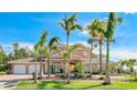 Elegant two-story waterfront home boasts lush landscaping and towering palm trees, creating a tropical paradise at 202 Gaines Ave, Sarasota, FL 34243