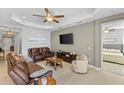 Inviting living room with leather sofas, tray ceiling, and neutral colors at 220 Cassano Dr, Nokomis, FL 34275