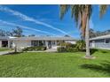 Inviting single-story home with lush green lawn and a beautiful palm tree in the front yard at 2406 Breakwater Cir, Sarasota, FL 34231