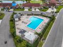 Aerial view of a community pool, surrounded by lush landscaping, lounge chairs, and cabanas at 2904 Captains Ct # 2904, Palmetto, FL 34221