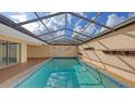 Enclosed pool area featuring cool blue pool water, ample sunlight, and tiled trim accents at 3692 Glen Oaks Manor Dr, Sarasota, FL 34232