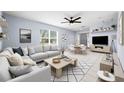 Bright living room featuring a comfortable gray sectional sofa, a ceiling fan, and a dining area at 3831 Day Bridge Pl, Ellenton, FL 34222