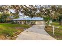 Home featuring a metal roof, long driveway, and well-maintained landscaping at 4045 Lisbon Pl, Sarasota, FL 34231