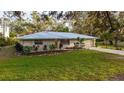 Well-maintained home with a metal roof, landscaping, and an attached garage at 4045 Lisbon Pl, Sarasota, FL 34231