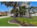 View of the front exterior highlighting the landscaping and mature trees surrounding the two-story house at 4255 67Th Avenue E Cir, Sarasota, FL 34243