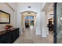 Bright foyer with neutral tile flooring, arched doorways, a large mirror and an open view to the living and dining rooms at 4255 67Th Avenue E Cir, Sarasota, FL 34243