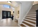 Foyer featuring neutral tile flooring, decorative front door, built-in bench, and staircase at 4255 67Th Avenue E Cir, Sarasota, FL 34243