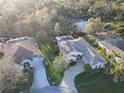 Aerial view of a home, with a screen enclosed pool, lush landscaping, and serene water views at 5139 50Th W Ave, Bradenton, FL 34210