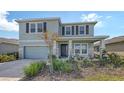 Inviting two-story home with stone accents, lush landscaping, and a manicured lawn at 5715 Woodland Sage Dr, Sarasota, FL 34238