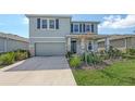 Two-story home with blue shutters, complemented by a lush landscaped yard at 5715 Woodland Sage Dr, Sarasota, FL 34238