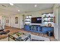 Bright living room with hardwood floors and custom blue shelving adds character to the space at 8192 Sternway Rd, Sarasota, FL 34240