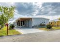 Well-maintained home with a covered carport, lush lawn, and inviting front entrance at 970 Jolanda Cir, Venice, FL 34285