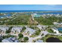 Stunning aerial view of the community with beautiful ocean views, lush landscaping, and well-maintained roads at 10600 Lemon Creek Loop # 102, Englewood, FL 34224