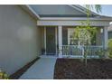 Inviting front porch with a gray door, decorative wreath, and white railing that provides a welcoming curb appeal at 10919 Blue Magnolia Ln, Parrish, FL 34219