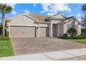 Beautiful home featuring a three-car garage, meticulously landscaped front yard, and an inviting entrance at 12423 Blue Hill Trl, Lakewood Ranch, FL 34211