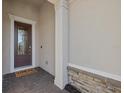Inviting front entry featuring a decorative glass door, welcome mat and brick-paver flooring at 12423 Blue Hill Trl, Lakewood Ranch, FL 34211
