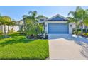 Beautiful single-Gathering home featuring a well-manicured lawn and vibrant blue two-car garage door at 4516 Renwick Dr, Parrish, FL 34219