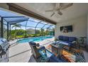 Inviting covered patio with comfortable seating, outdoor television, and view of the sparkling pool at 4516 Renwick Dr, Parrish, FL 34219