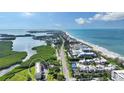 Stunning aerial view showcasing beachfront condos, pristine beaches, and serene waterfront at 4600 Gulf Of Mexico Dr # 202, Longboat Key, FL 34228