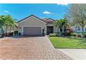 Charming home featuring a brick driveway, a two-car garage, and tropical landscaping at 4632 Benito Ct, Lakewood Ranch, FL 34211