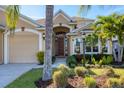 Welcoming home with a grand entryway, lush garden beds, and a convenient two-car garage at 4724 Tilden Park Ct, Bradenton, FL 34211
