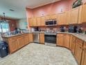 Well-lit kitchen features wood cabinetry, stainless steel appliances, and granite countertops at 4839 Turtle Bay Ter, Bradenton, FL 34203