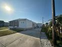 Exterior view of home with a long driveway, screened porch, and storage shed at 508 51St W Ave, Bradenton, FL 34207