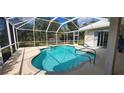Refreshing screened-in pool with a spa and a scenic view of the trees at 629 Sawgrass Bridge Rd, Venice, FL 34292