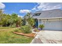 Inviting exterior showcasing the home's entrance, well-maintained landscaping and blue accent door at 7892 S Leewynn Pl, Sarasota, FL 34240
