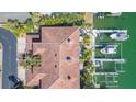 Stunning aerial view shows a waterfront home, boat dock with lifts, and lush greenery at 903 Pinellas Bayway S # 102, St Petersburg, FL 33715