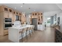 Well-lit kitchen featuring a large island with seating, modern appliances, and light wood cabinetry throughout at 9998 Key Haven Rd, Seminole, FL 33777
