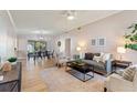 Inviting living room with stylish gray sofa, wood floors, and adjacent dining area at 1604 Edna Ave, Largo, FL 33770