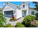 Charming two-story home featuring a blue front door, well-manicured landscaping, and a two-car garage at 2720 Butterfly Jasmine Trl, Sarasota, FL 34240