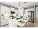 Modern kitchen featuring white cabinets, stainless steel appliances, quartz countertops, and pendant lighting at 2720 Butterfly Jasmine Trl, Sarasota, FL 34240
