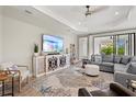 Cozy living room with a large TV, comfortable seating, stylish rug, and lots of natural light at 2720 Butterfly Jasmine Trl, Sarasota, FL 34240