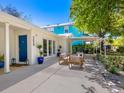 Exterior patio with comfortable seating area, blue front door, and manicured landscaping at 3629 Almeria Ave, Sarasota, FL 34239